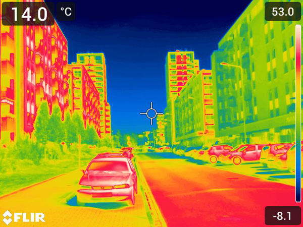 Thermal image of a housing estate; the street and cars appear red, while vegetation and shaded objects are green