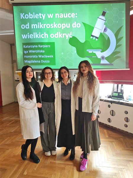 Four young women pose for a photo in front of a presentation titled: women in science